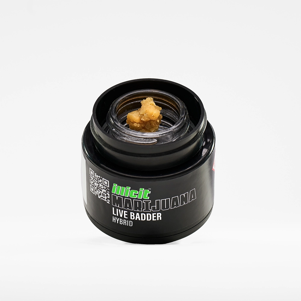 Illicit Marijuana Live Badder Hybrid concentrate in a black glass container, featuring a close-up view of the golden cannabis extract inside