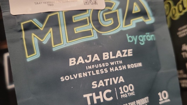 Close-up of MEGA by Grön Baja Blaze cannabis edibles packaging, infused with solventless hash rosin. Sativa, 100mg THC, available at Theo Dispensary.