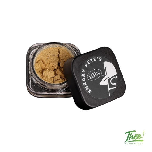 Sneaky Pete’s cannabis kief in an open glass container with branded black lid beside it