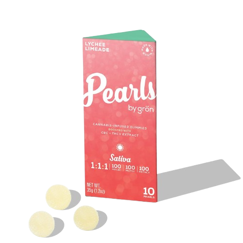 Three pale yellow gummies sit in front of a coral box of GRÖN Lychee Limeade Pearls